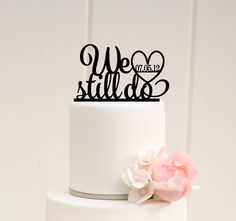 there is a wedding cake with two hearts on top and the word we still do