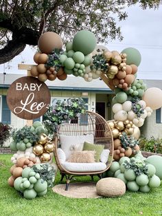 a baby shower is decorated with balloons and greenery