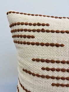 a white and brown pillow sitting on top of a table