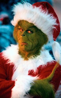 a man dressed as the grinch in a santa suit and holding his arms crossed