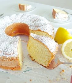 there is a cake that has been sliced and served on a plate with lemons