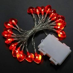 a bunch of red and white lights on a black surface with wires connected to them