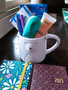 a mug filled with office supplies on top of a table