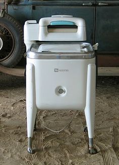 an old car is parked next to a cooler