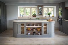 a large kitchen with an island in the middle and lots of cupboards on both sides