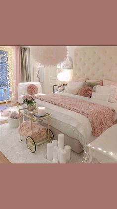 a bedroom decorated in pink and white with lights on the ceiling, chandelier above bed