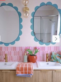 a bathroom with two sinks and mirrors on the wall