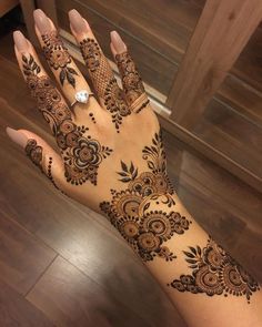 a woman's hand with henna tattoos on it