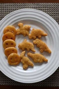 a white plate topped with cut up animals on top of it's side next to crackers