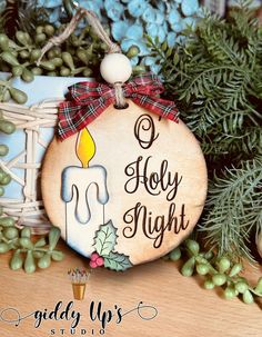 a wooden ornament with a candle on it and holly wreath in the background