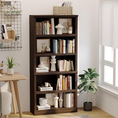 a bookshelf filled with lots of books next to a window