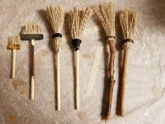 five different types of brooms lined up in a row on top of a table