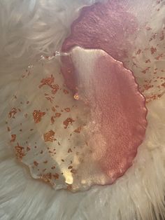 a white fur with pink and gold flecks on it's back end