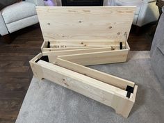 a wooden box sitting on top of a carpeted floor next to a gray couch