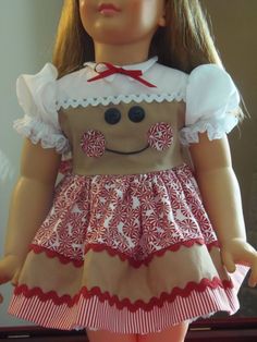 the doll is wearing a red and white dress with a smile on it's face