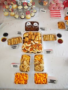 a table topped with lots of trays filled with different types of foods and desserts