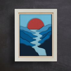 a paper cut art piece with mountains and a sunset