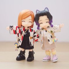 two dolls are standing next to each other