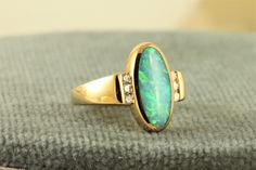 "This is another great Kabana Opal Ring in 18K gold.  Kabana is a US company first noted for their inlaid jewelry.  This ring has a lovely Black Opal stone adorned by bright and well matched Diamond stones. The face of the ring is 5/8\" by 3/8\" and weighs 5.9 in size 5.5. It is fully hallmarked Kabana and is in excellent estate condition." Opal Rings With Polished Finish For Formal Occasions, Formal Opal Rings With Polished Finish, Elegant Green Rings With Inlay, Elegant Green Inlay Rings, Elegant Gold Rings With Inlay, Elegant Green Jewelry With Inlay, Elegant 14k Gold Jewelry With Inlay, Elegant Yellow Gold Jewelry With Inlay, Elegant Green Opal Ring For Formal Occasions