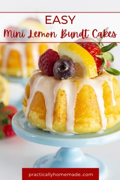 a lemon bundt cake with icing and fruit on top, sitting on a blue plate