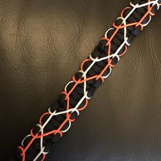 an orange and white rope on top of a black leather seat cushion with red, white, and blue stitching