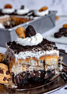 a piece of ice cream cake on a plate with cookies and oreo pieces around it