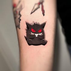 a black cat with red eyes is on the arm