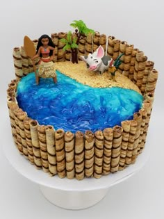 a cake that is made to look like a desert with blue water and bamboo sticks