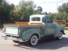 an old pick up truck parked in a parking lot