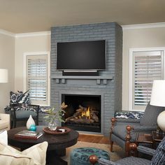 a living room filled with furniture and a flat screen tv mounted above the fire place