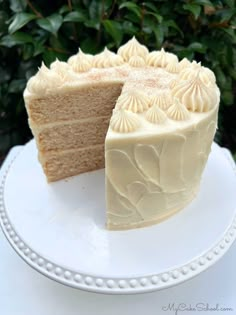 a white cake on a plate with one slice cut out