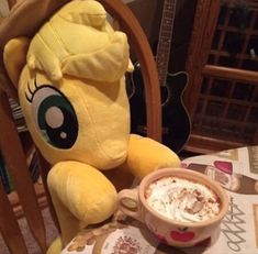 a stuffed animal sitting next to a cup of coffee