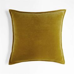 a yellow velvet pillow on a white background