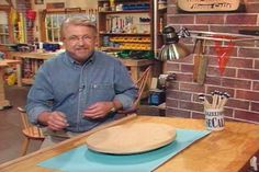 a man sitting at a table with a wooden plate on it