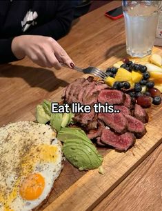 someone is cutting up some food on a wooden board with the words eat like this