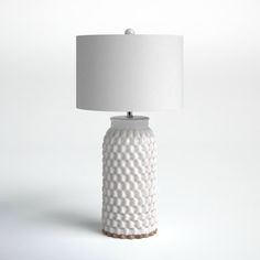 a white ceramic table lamp with a white shade