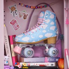 a pair of roller skates sitting on top of a pink shelf next to books