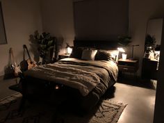 a dimly lit bedroom with guitar lights on the bed