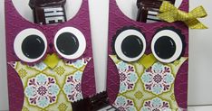 two purple owls are holding chocolate bars with googly eyes and bows on their heads