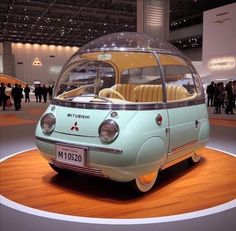 the small car is on display at an auto show