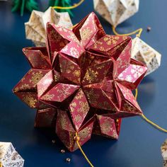 an origami star is shown on the table with other paper decorations around it