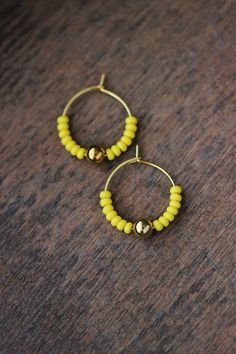 Cute summer earrings with bright lemon yellow glass seed beads,gold tone sphere beads and gold tone stainless steel round hoop earrings. Earring hooks are from nickel free and lead free metal. Perfect jewelry for everyday wear or a great gift for someone special! Diameter of hoops is 20 mm. Other earrings of my shop you can see here: https://www.etsy.com/shop/NaTavelli?section_id=13757927 Thanks for visit. Earring Simple, Minimalist Summer, Earring Hoops, Earring Ring, Ring Earring, Small Beads, Earring Gold, Yellow Earrings, Summer Earring