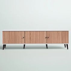 the sideboard is made out of wood and has three drawers, one with black legs