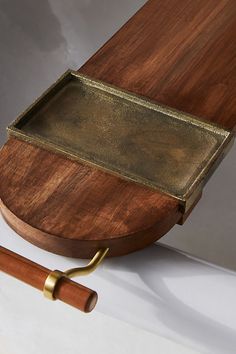 a wooden table with a metal tray on it and a pen resting next to it