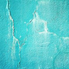 a blue wall with cracks in it and some paint peeling off the side of it