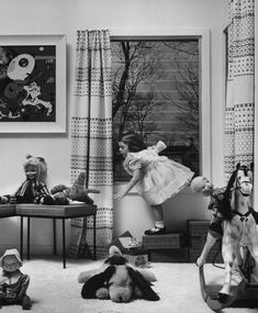 black and white photograph of children playing in their living room with toys on the floor