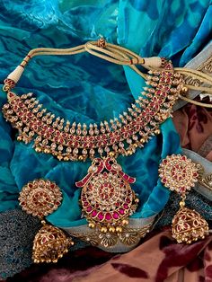 Experience opulence with our exquisite jewelry set, crafted by the same skilled artisans who create real gold pieces. Fashioned from top-quality materials, it mirrors the allure of genuine gold without the price tag. Perfect for destination weddings and parties, its elegance is matched only by its convenience and security for travel. Product Details: Material: Each piece is meticulously handcrafted from high-quality brass and Kundan Stones. Necklace Dimensions: Weight: 85 grams Closure Type: Pre Gold Jewelry With Stone Work For Celebration, Diwali Yellow Gold Round Jewelry Sets, Diwali Gold Jewelry With Stone Work, Elegant Round Temple Necklace As A Gift, 22k Gold Jewelry Sets For Celebration, Elegant Temple Necklace As Gift, Festive 22k Gold Jewelry Sets, Gold Temple Jewelry With Stone Work, Luxury Stone Work Jewelry Sets For Festive Occasion