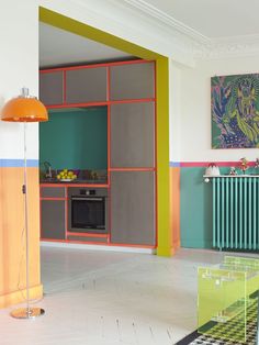 a kitchen with colorful walls and flooring next to a table in front of an oven