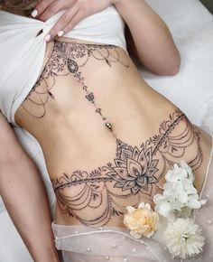 a woman laying on top of a bed covered in tattoos