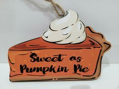 a wooden sign that says sweet as pumpkin pie hanging from a rope on a wall